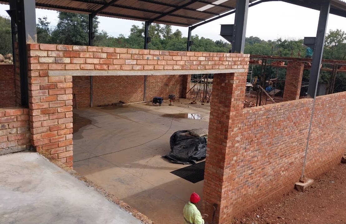 Brick office and support spaces being integrated with the workshop steel structure