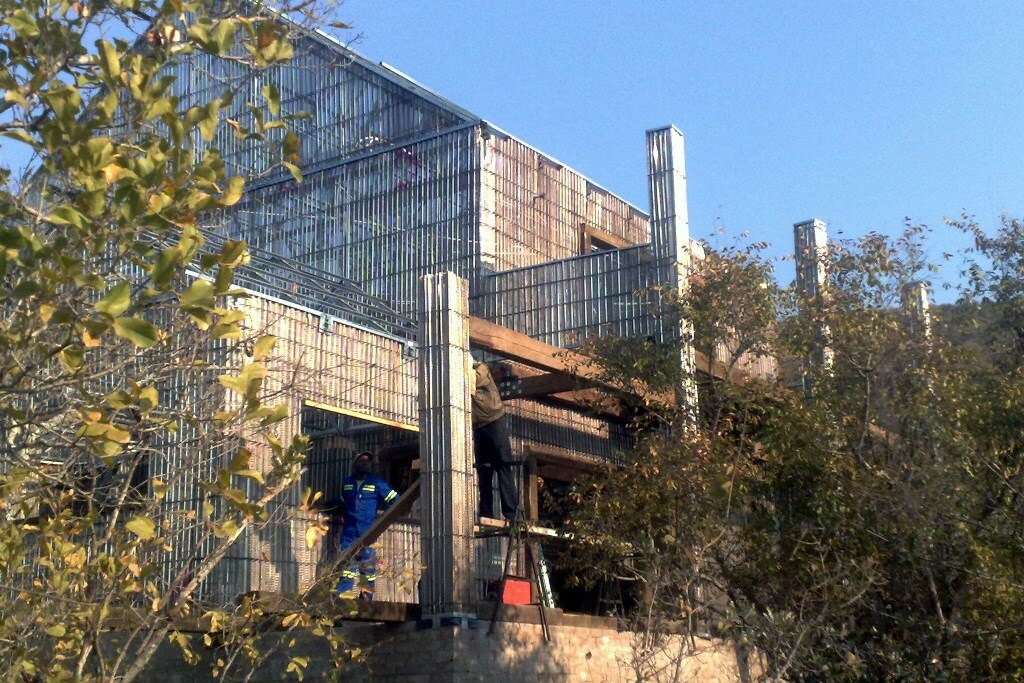 Robust expanded-steel core wall panels installed before structural mortar application
